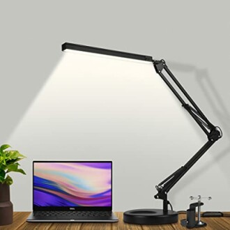 Lampe de bureau réglable éclairant un ordinateur portable sur une table.