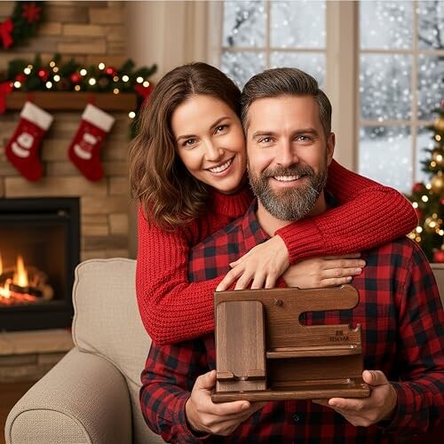 Couple souriant avec cadeau devant cheminée décorée pour Noël